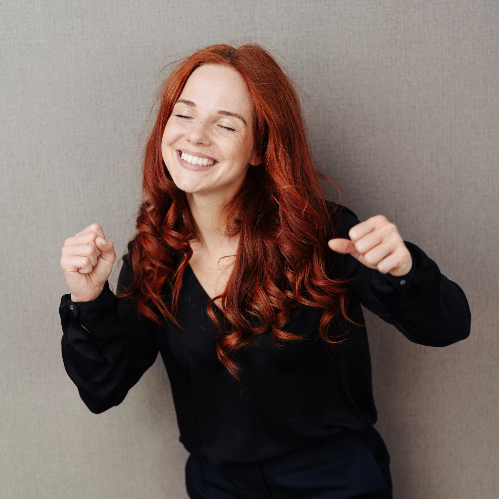 Excited enthusiastic young redhead woman